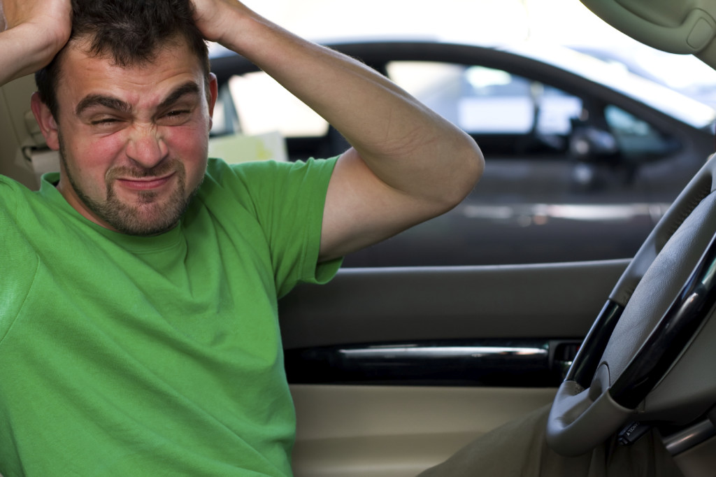 A portrait of an angry driver sitting in his car.